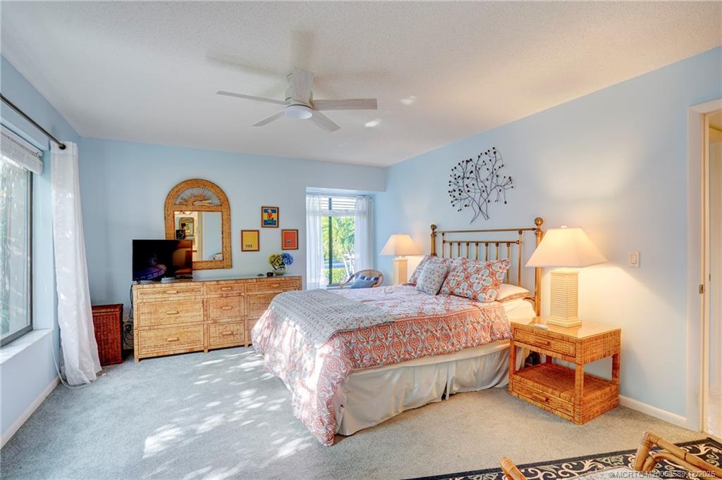 233 Northeast Edgewater Drive, Unit 204 Stuart, FL 34996 - Photo 30 of 56 a bedroom with a large bed and a dresser