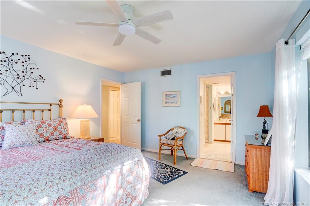 233 Northeast Edgewater Drive, Unit 204 Stuart, FL 34996 - Photo 31 of 56 a bedroom with a bed and a chandelier