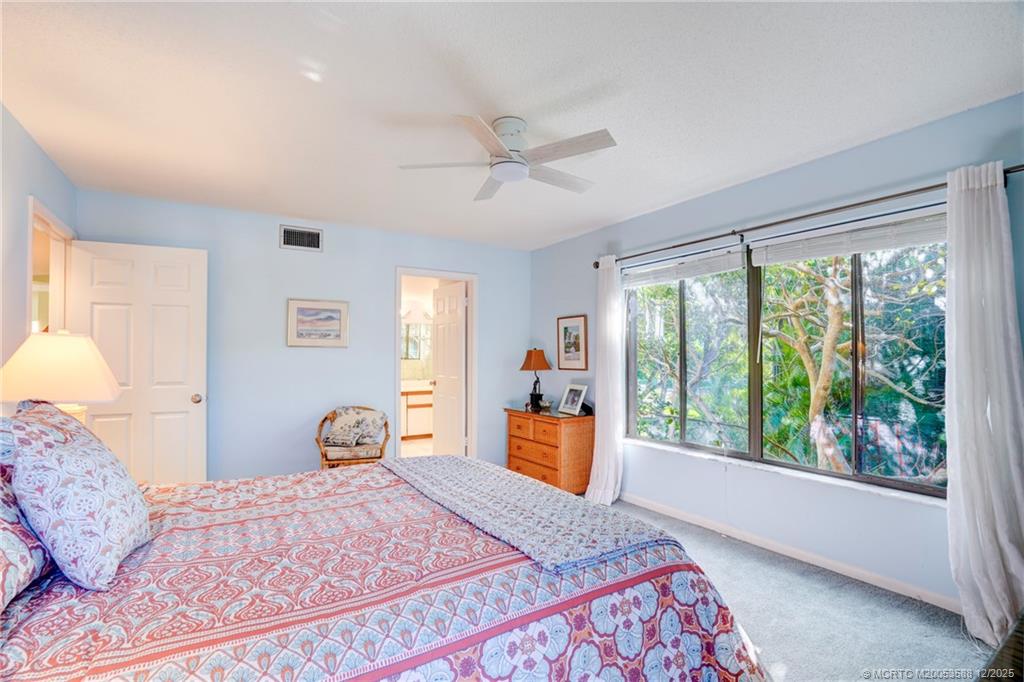 233 Northeast Edgewater Drive, Unit 204 Stuart, FL 34996 - Photo 32 of 56 a bedroom with a large bed and a large window