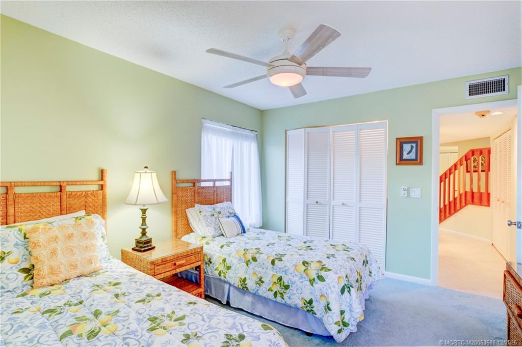 233 Northeast Edgewater Drive, Unit 204 Stuart, FL 34996 - Photo 39 of 56 a bedroom with a bed and a chandelier