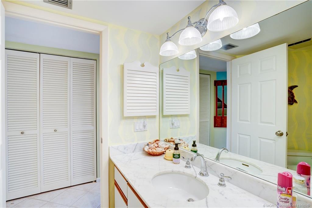 233 Northeast Edgewater Drive, Unit 204 Stuart, FL 34996 - Photo 41 of 56 a bathroom with a sink a vanity and a mirror