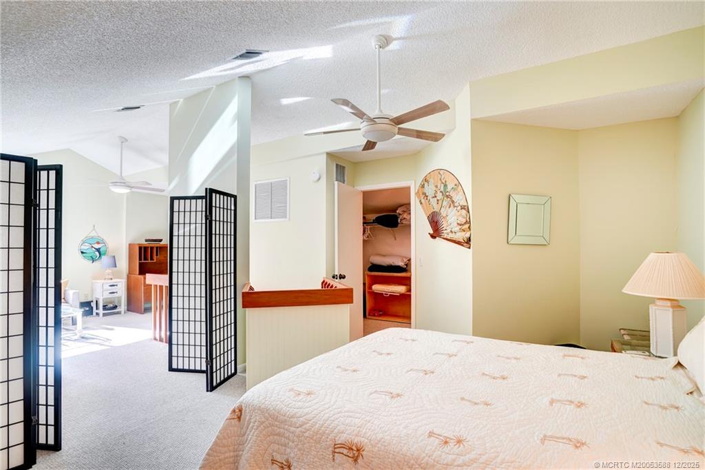 233 Northeast Edgewater Drive, Unit 204 Stuart, FL 34996 - Photo 49 of 56 a bedroom with a bed closet and a flat tv screen