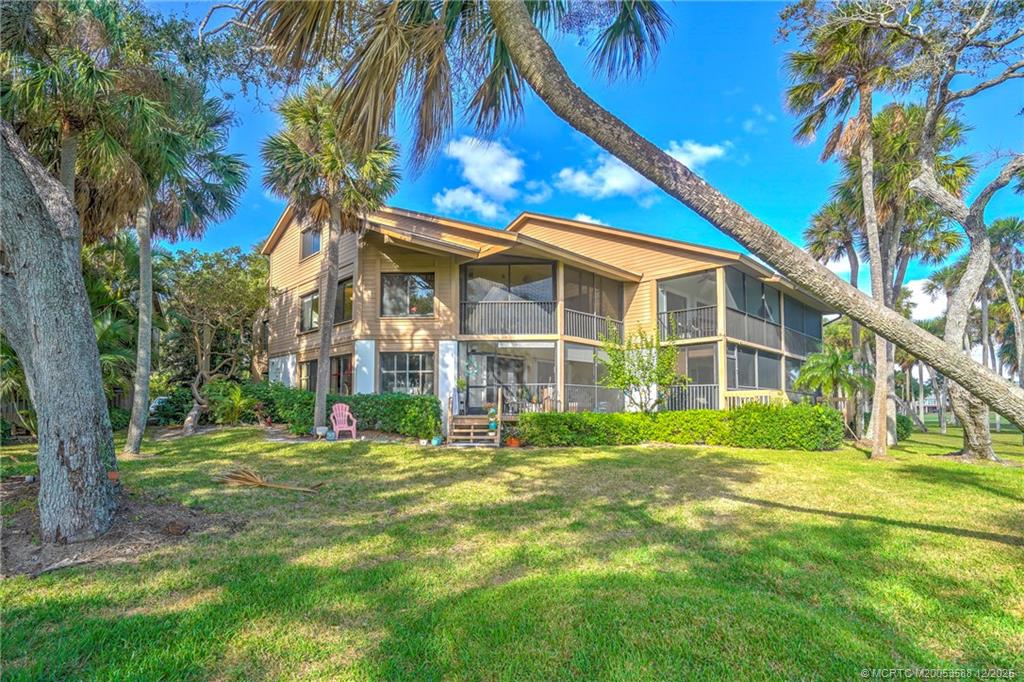 233 Northeast Edgewater Drive, Unit 204 Stuart, FL 34996 - Photo 5 of 56 a view of a house with a big yard and large trees