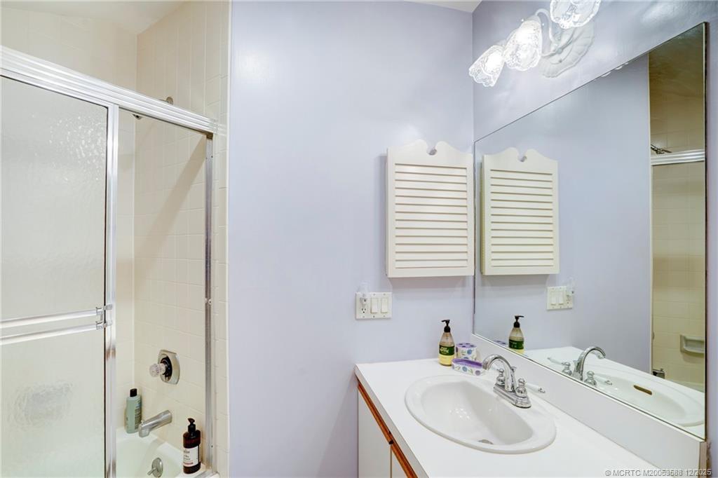 233 Northeast Edgewater Drive, Unit 204 Stuart, FL 34996 - Photo 53 of 56 a bathroom with a sink a mirror and a shower