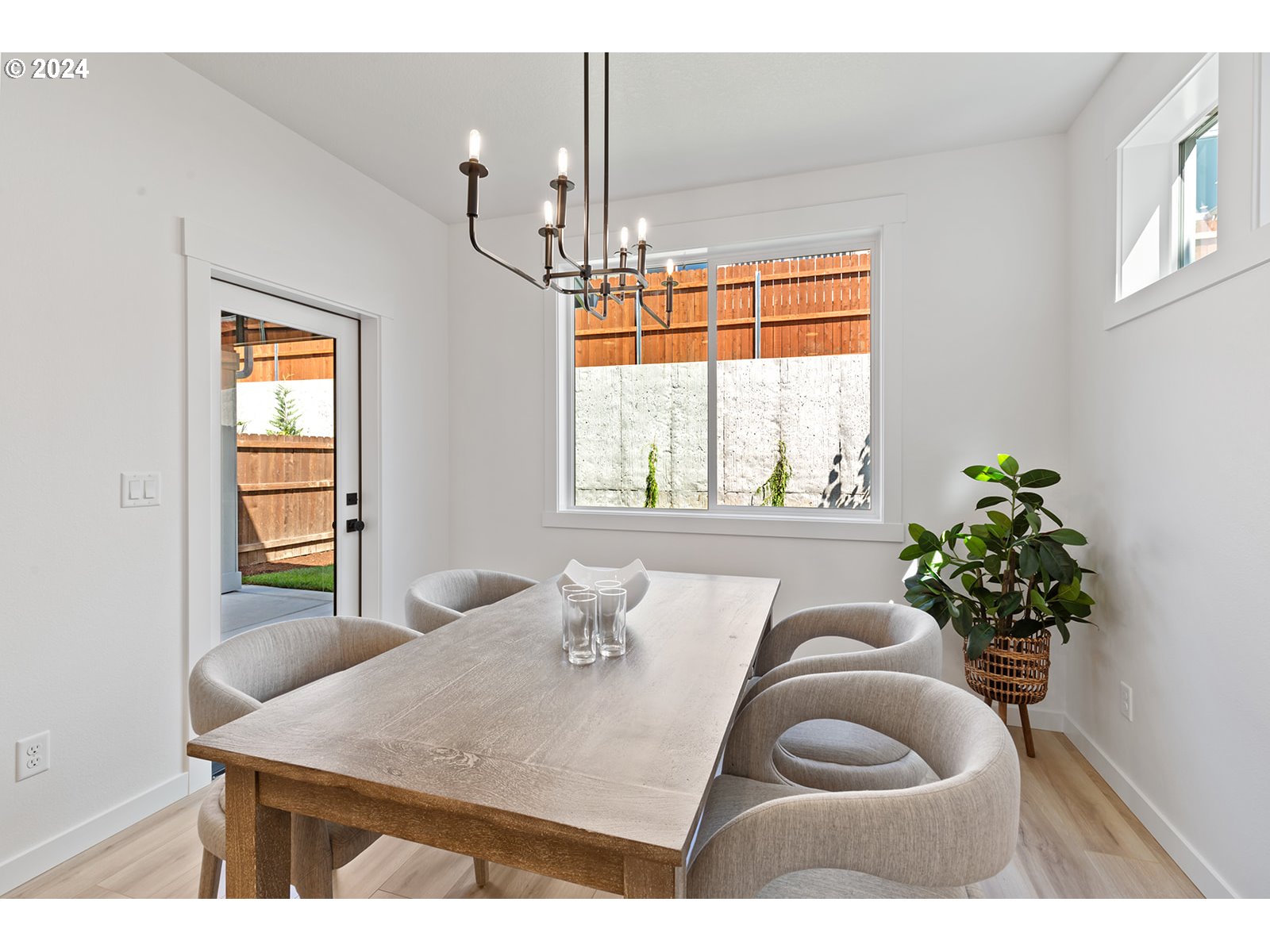 820 Northwest 178th Street Ridgefield, WA 98642 - Photo 24 of 45 a dining room with wooden floor a chandelier a potted plant and windows