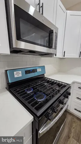 a stove top oven sitting inside of a kitchen