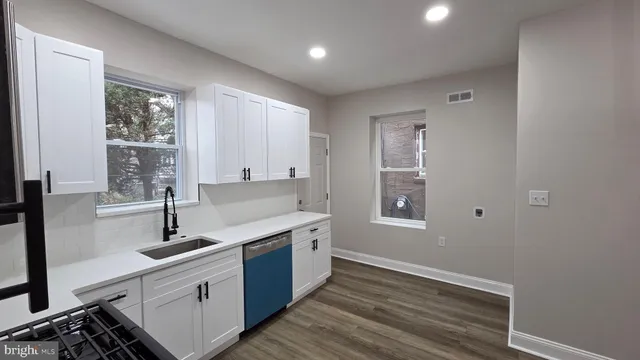a view of a kitchen with sink large windows and plants