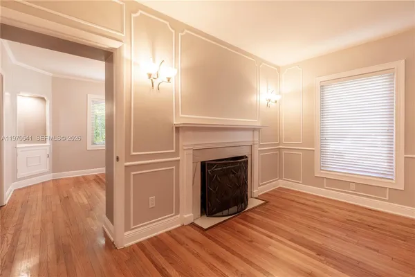 a view of empty room with wooden floor and fireplace