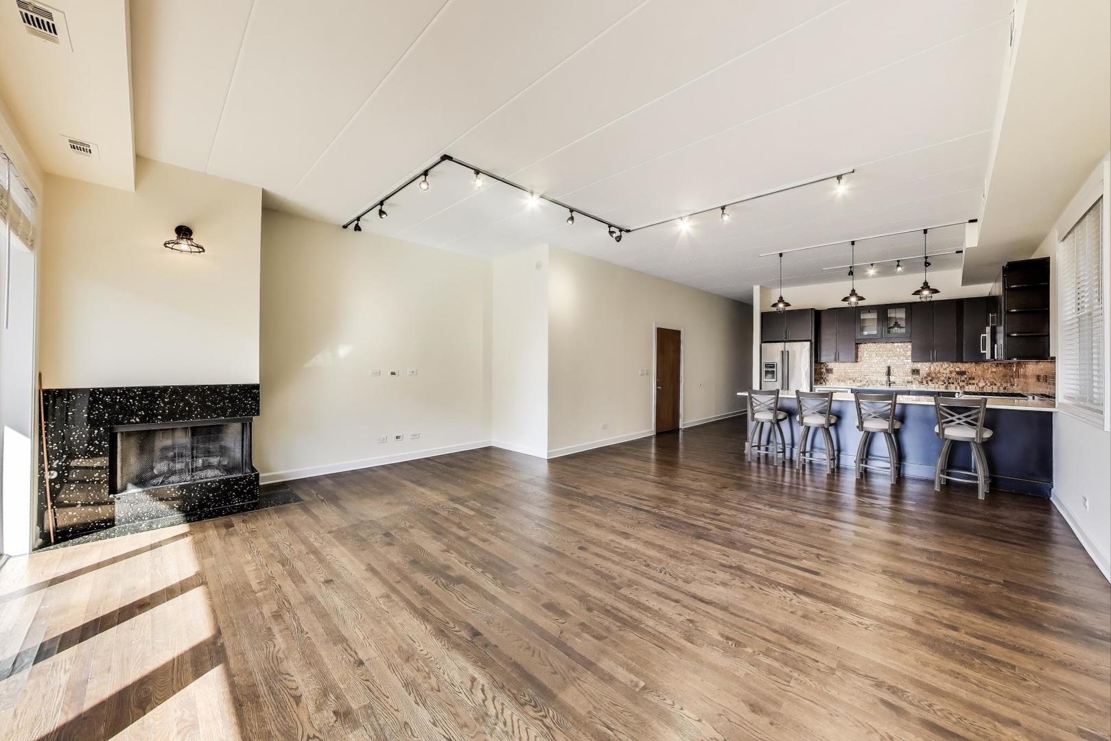 1332 West Madison Street, Unit 4E Chicago, IL 60607 - Photo 3 of 12 a kitchen with stainless steel appliances a refrigerator and a stove top oven