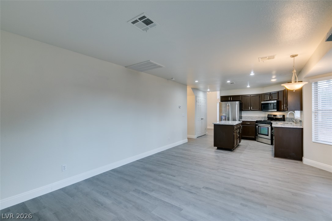1738 Toltec Circle Henderson, NV 89014 - Photo 30 of 46 A well-lit, open-concept living area with durable flooring flows into a contemporary kitchen.