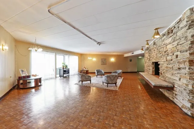 a living room with fireplace furniture and a large window