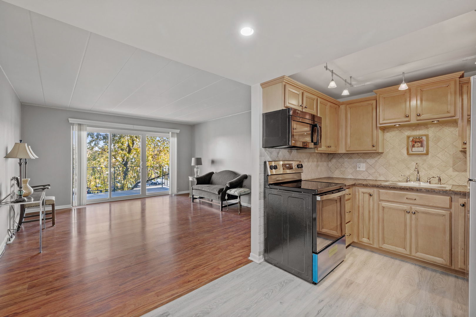 5540 Walnut Avenue, Unit 6B Downers Grove, IL 60515 - Photo 8 of 25 a kitchen with stainless steel appliances granite countertop a stove top oven a sink dishwasher a dining table and chairs with wooden floor