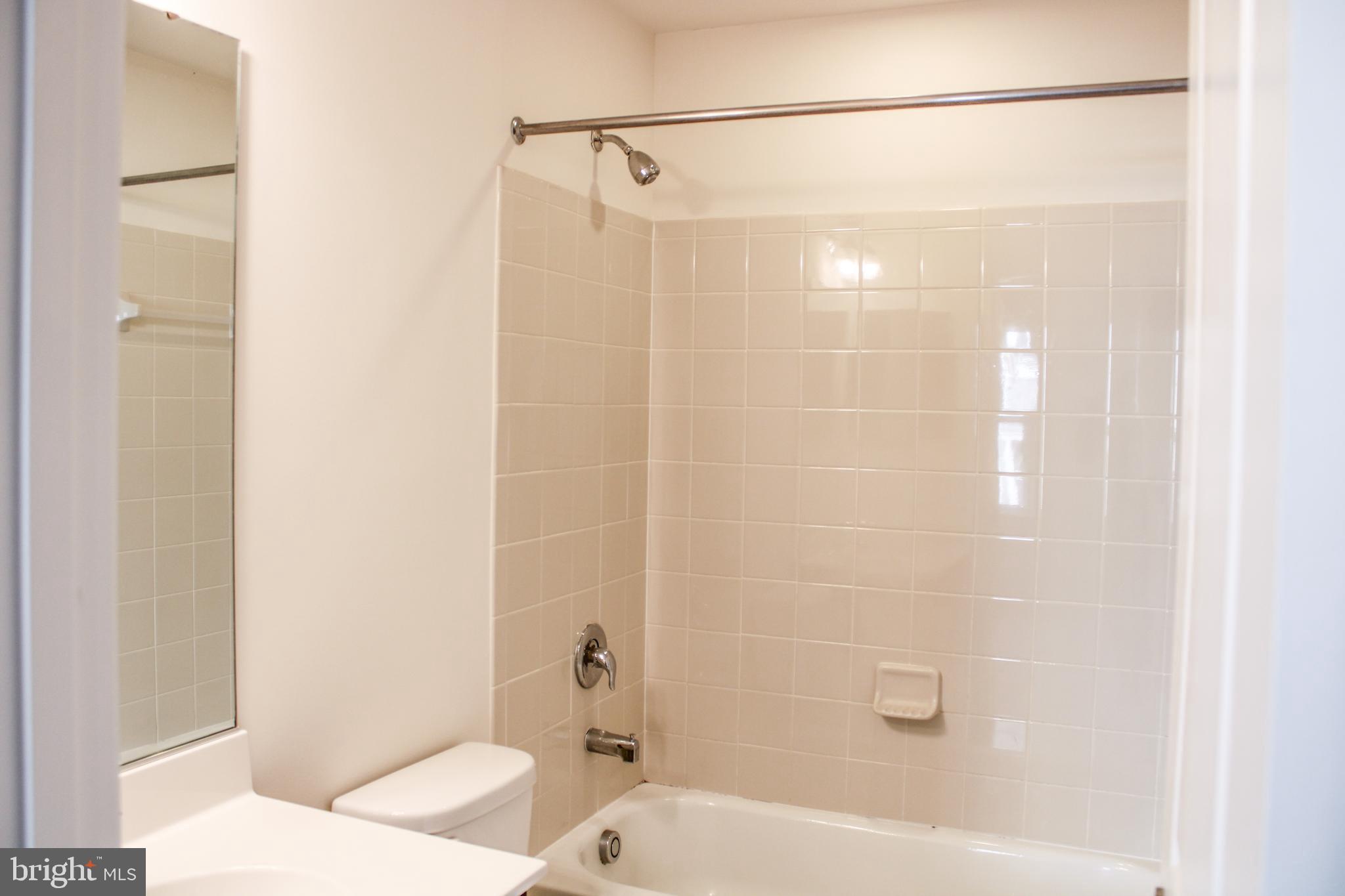 9914 Wood Edge Way Lanham, MD 20706 - Photo 13 of 67 a bathroom with a bathtub and a shower