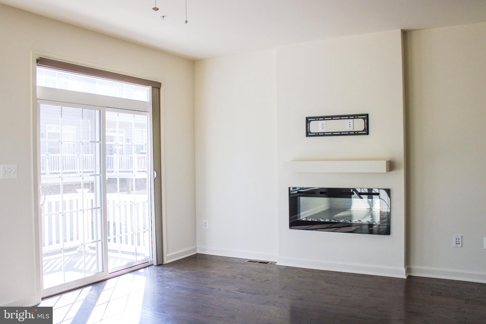 9914 Wood Edge Way Lanham, MD 20706 - Photo 22 of 67 a view of an empty room with wooden floor and a window