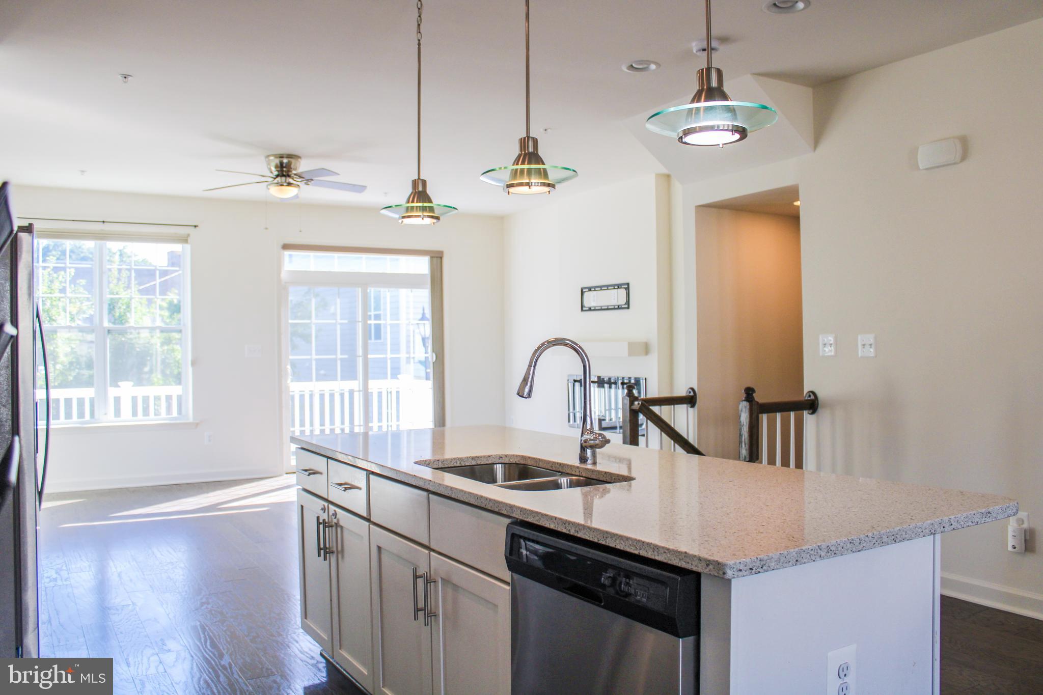 9914 Wood Edge Way Lanham, MD 20706 - Photo 25 of 67 a kitchen with kitchen island granite countertop a sink stainless steel appliances and cabinets