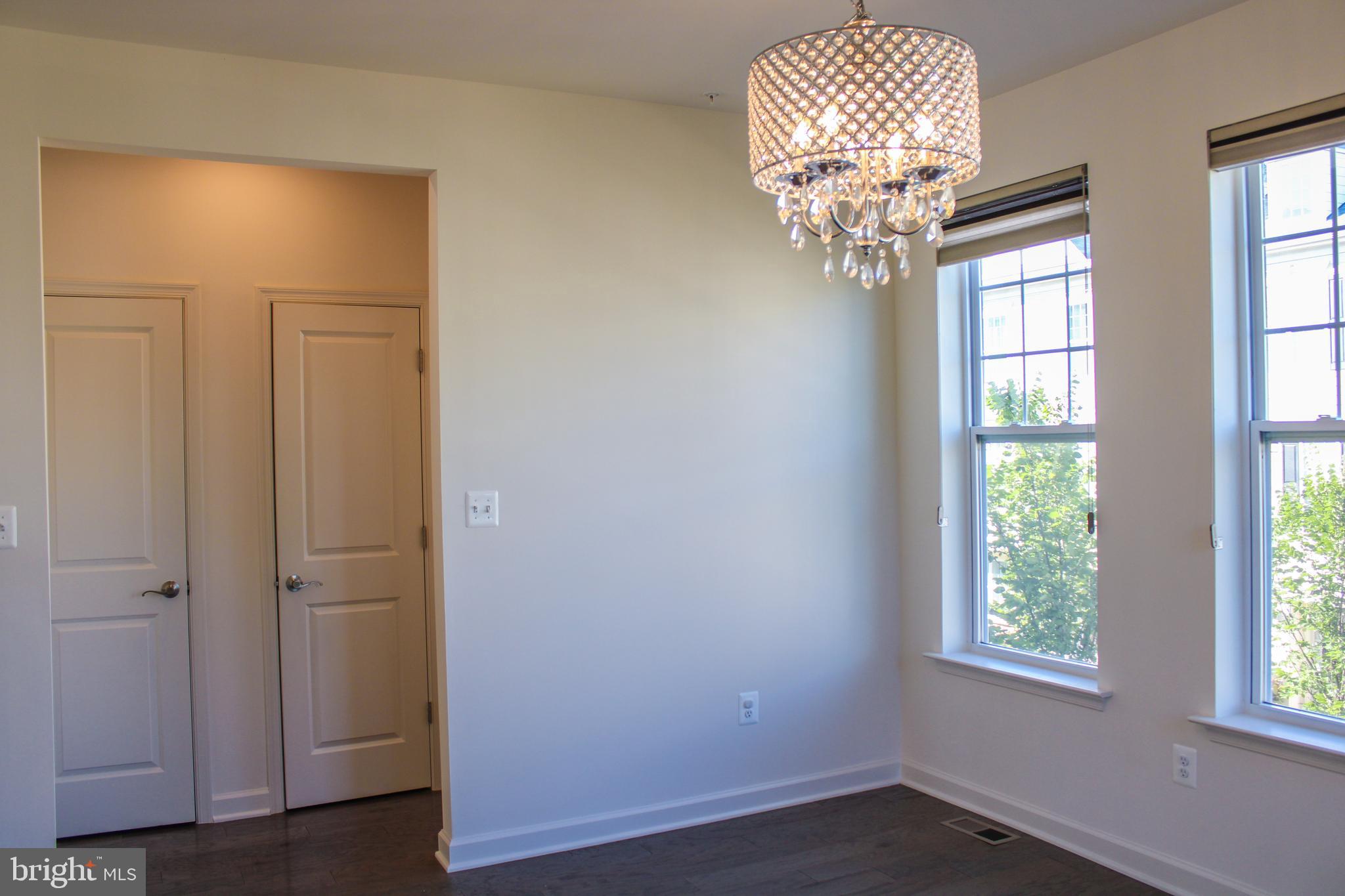 9914 Wood Edge Way Lanham, MD 20706 - Photo 33 of 67 an empty room with wooden floor chandelier and closet