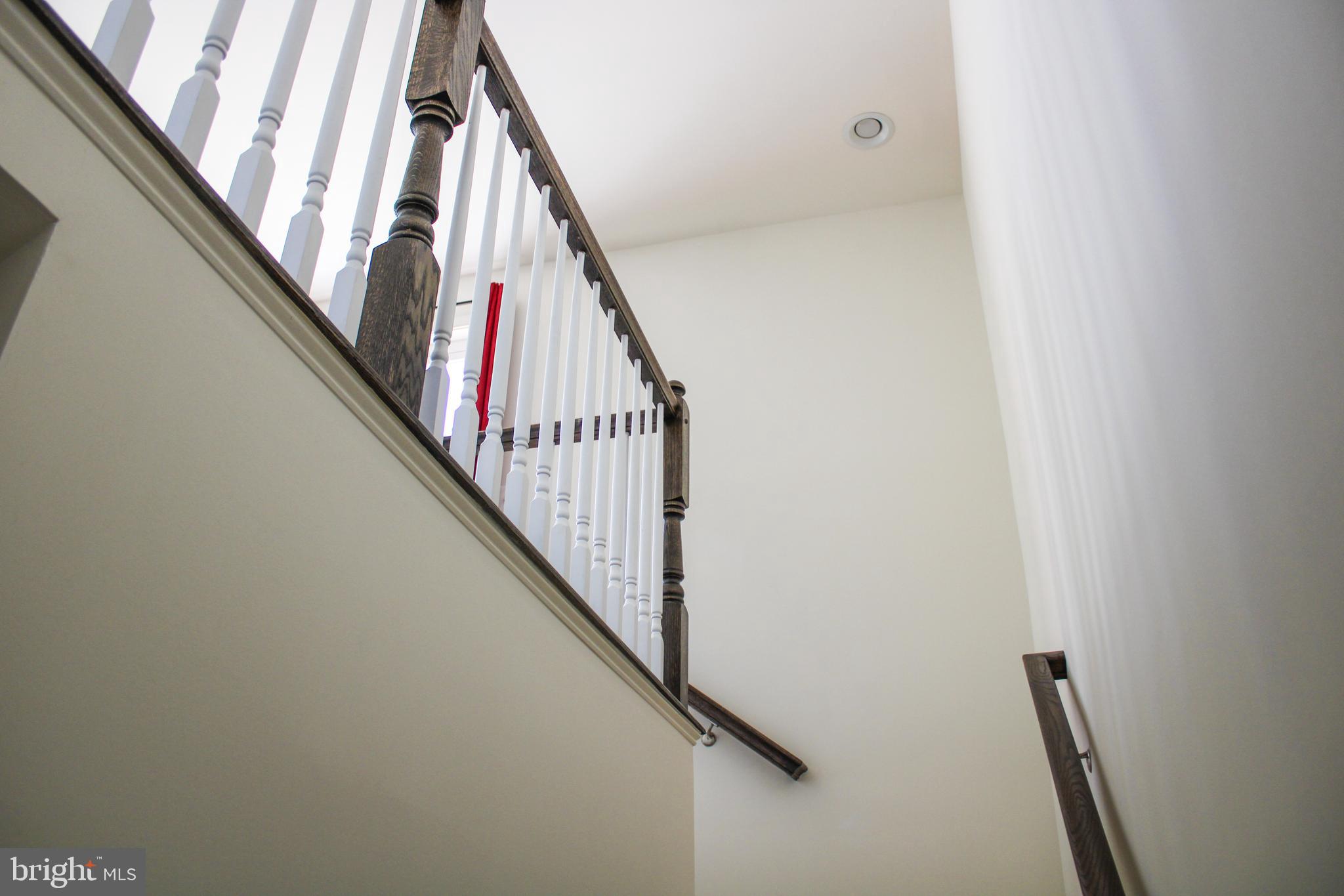 9914 Wood Edge Way Lanham, MD 20706 - Photo 59 of 67 a view of staircase with wooden floor and white walls