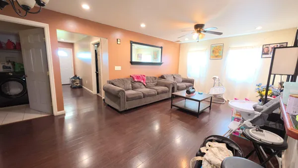 a living room with furniture and wooden floor