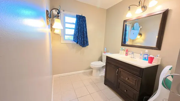 a bathroom with a toilet a sink and mirror