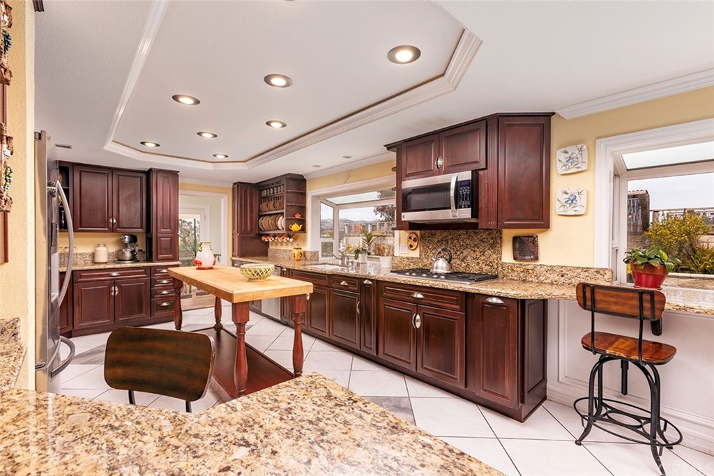 23965 Leeward Drive Dana Point, CA 92629 - Photo 4 of 27 a kitchen with stainless steel appliances kitchen island granite countertop a refrigerator and a stove top oven