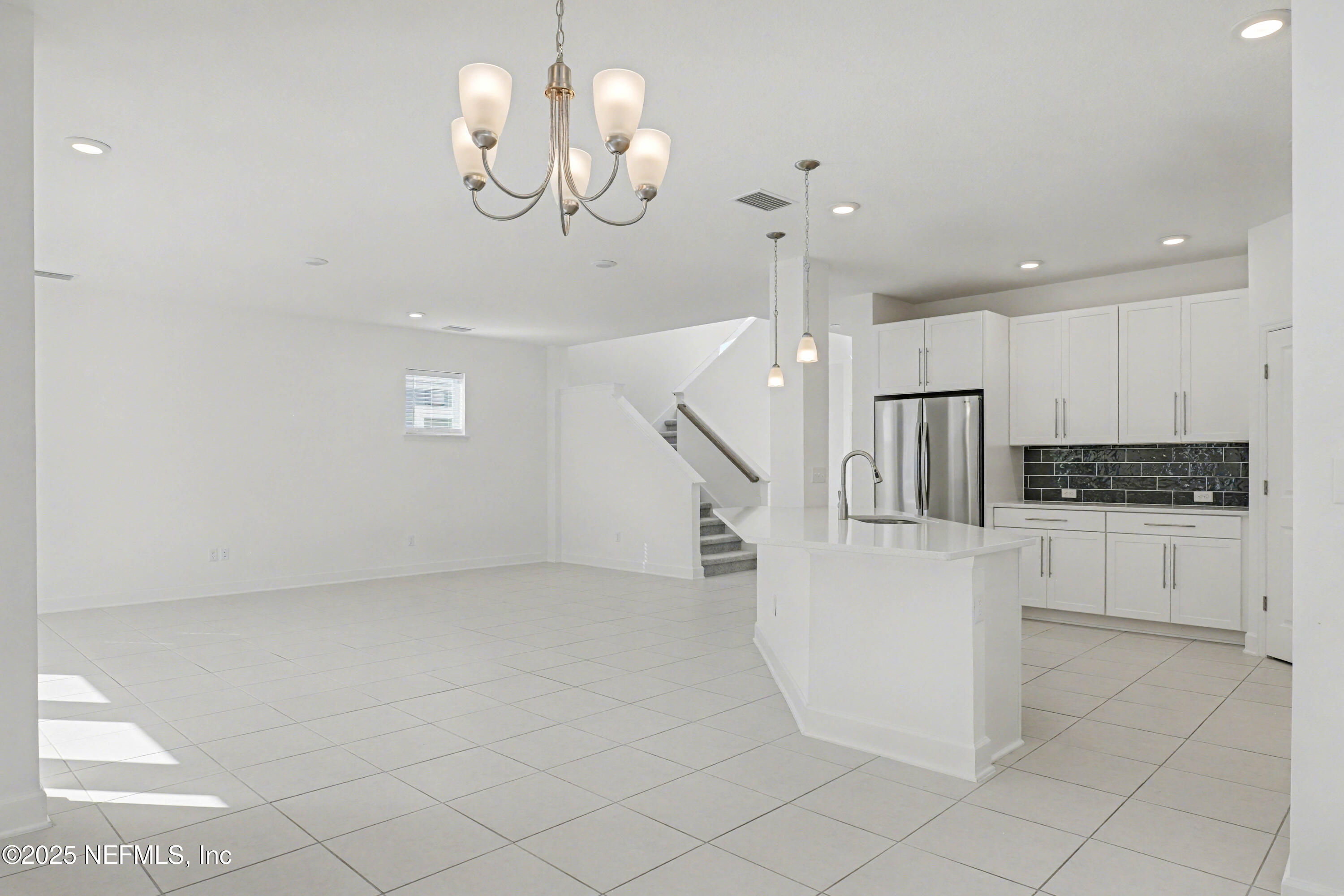 111 Windswept Way St. Augustine, FL 32092 - Photo 11 of 63 a kitchen with white cabinets and chandelier