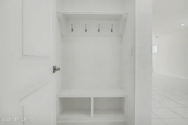 a view of a hallway with staircase and white walls