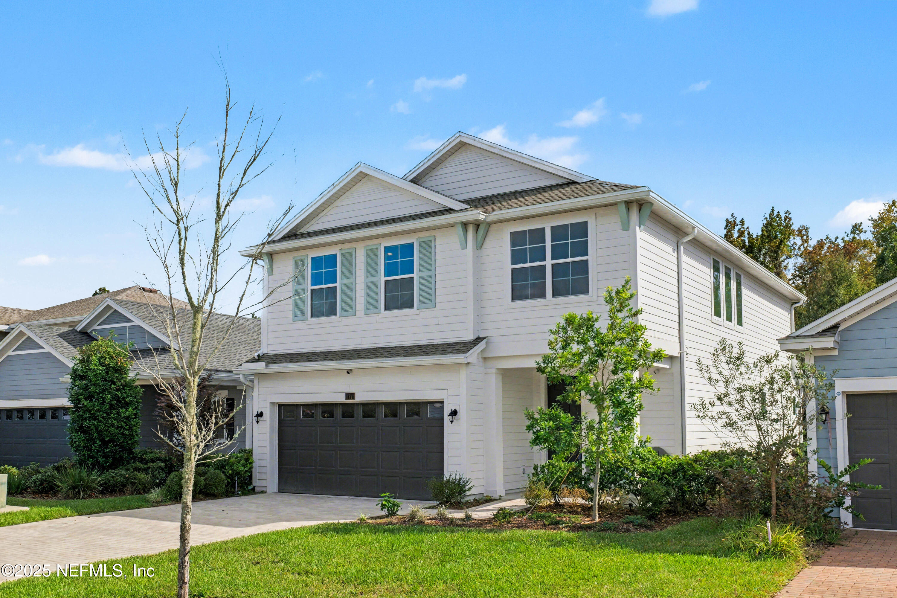 111 Windswept Way St. Augustine, FL 32092 - Photo 4 of 63 a front view of a house with a garden and garage