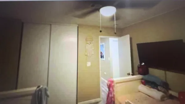 a bedroom with a bed and a fan