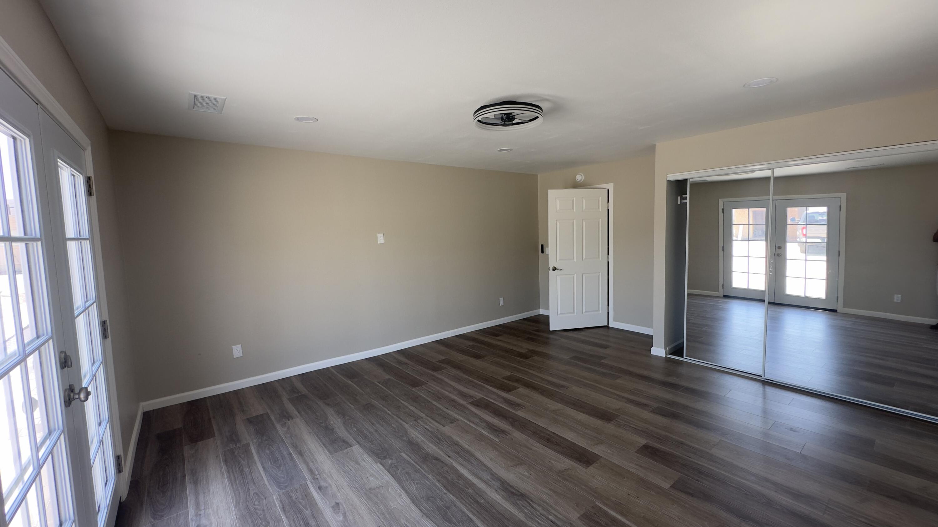 Undisclosed Address Desert Hot Springs, CA 92241 - Photo 8 of 29 an empty room with wooden floor and windows