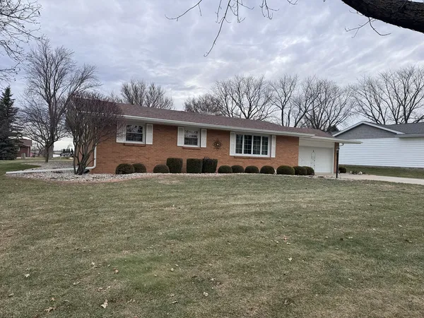 a front view of house with yard and trees around