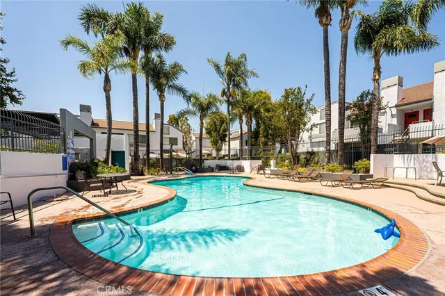 a view of a patio with table and chairs potted plants and palm trees
