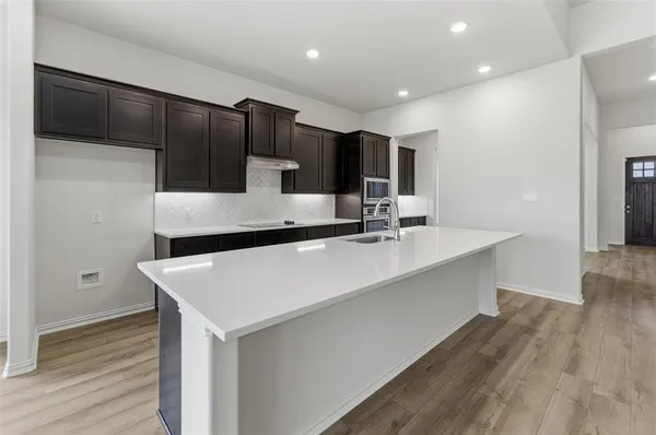 a kitchen with kitchen island a sink stove and refrigerator