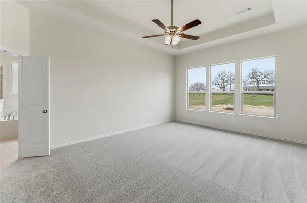 an empty room with windows and fan