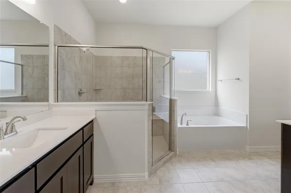 a bathroom with a bathtub sink vanity and mirror