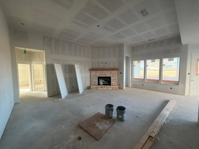 an empty room with a fireplace and window