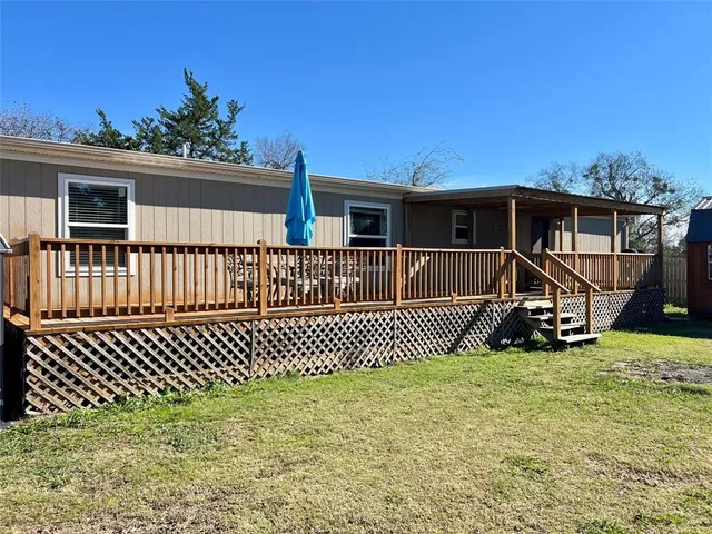 a view of a house with a small yard and wooden fence