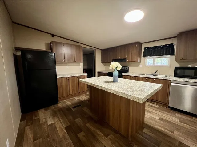 a kitchen with a sink a refrigerator and cabinets