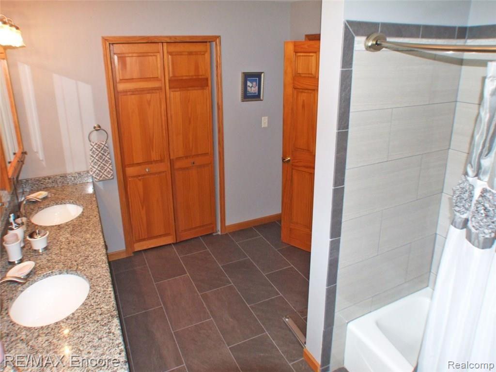 8945 Michigamme Road Clarkston, MI 48348 - Photo 17 of 30 Master bath with dual sinks, granite counters, ceramic floor and tub surround