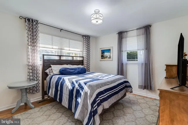 a bed room with a bed tv and a window