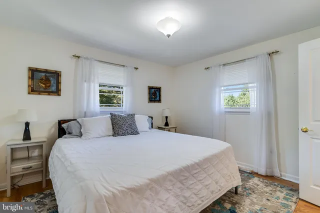 a bedroom with a bed and a window with wall mirror