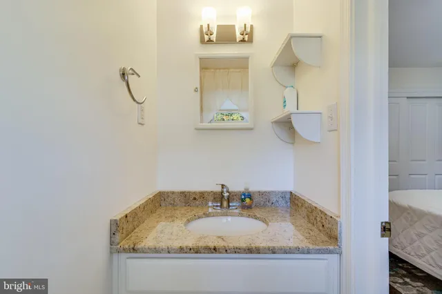 a bathroom with a granite countertop sink and a mirror
