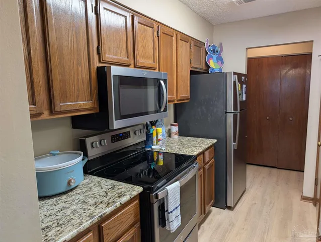 a kitchen with stainless steel appliances granite countertop a refrigerator stove and microwave