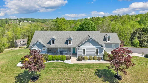 a aerial view of a house with a big yard and large trees