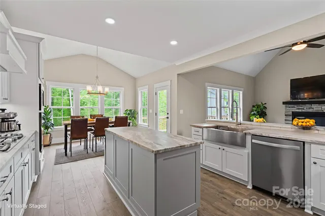a kitchen with counter top space a sink appliances and living room view