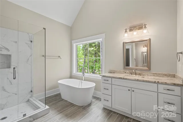 a spacious bathroom with a double vanity sink a mirror and a bathtub
