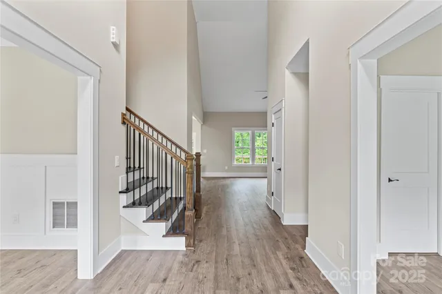 a view of a hallway with wooden floor and stairs