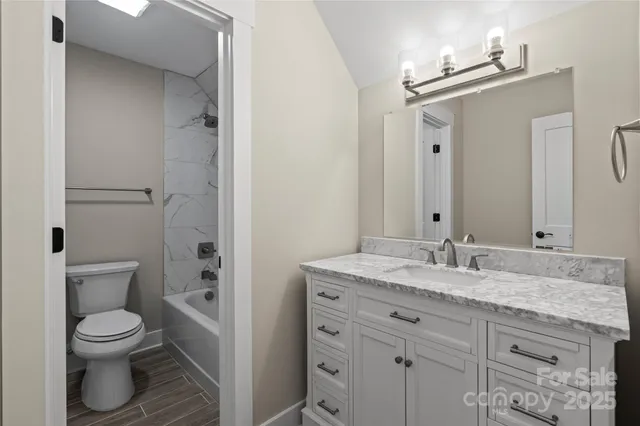 a bathroom with a granite countertop sink toilet and shower