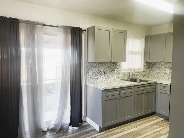 a bathroom with a granite countertop sink and a mirror