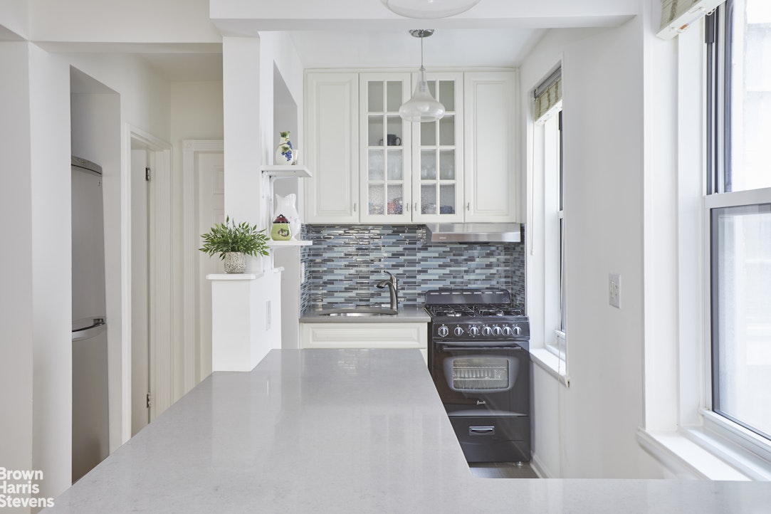 30 Monroe Place, Unit 1F Brooklyn, NY 11201 - Photo 3 of 7 a kitchen with white cabinets and window