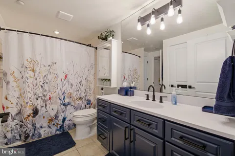 a bathroom with a double vanity sink toilet and a mirror